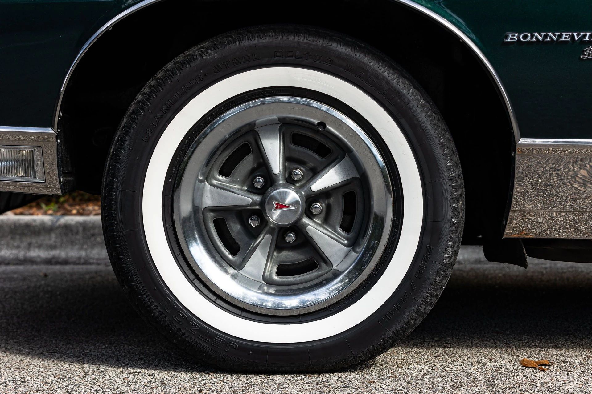 Styled wheel and whitewall on a green car
