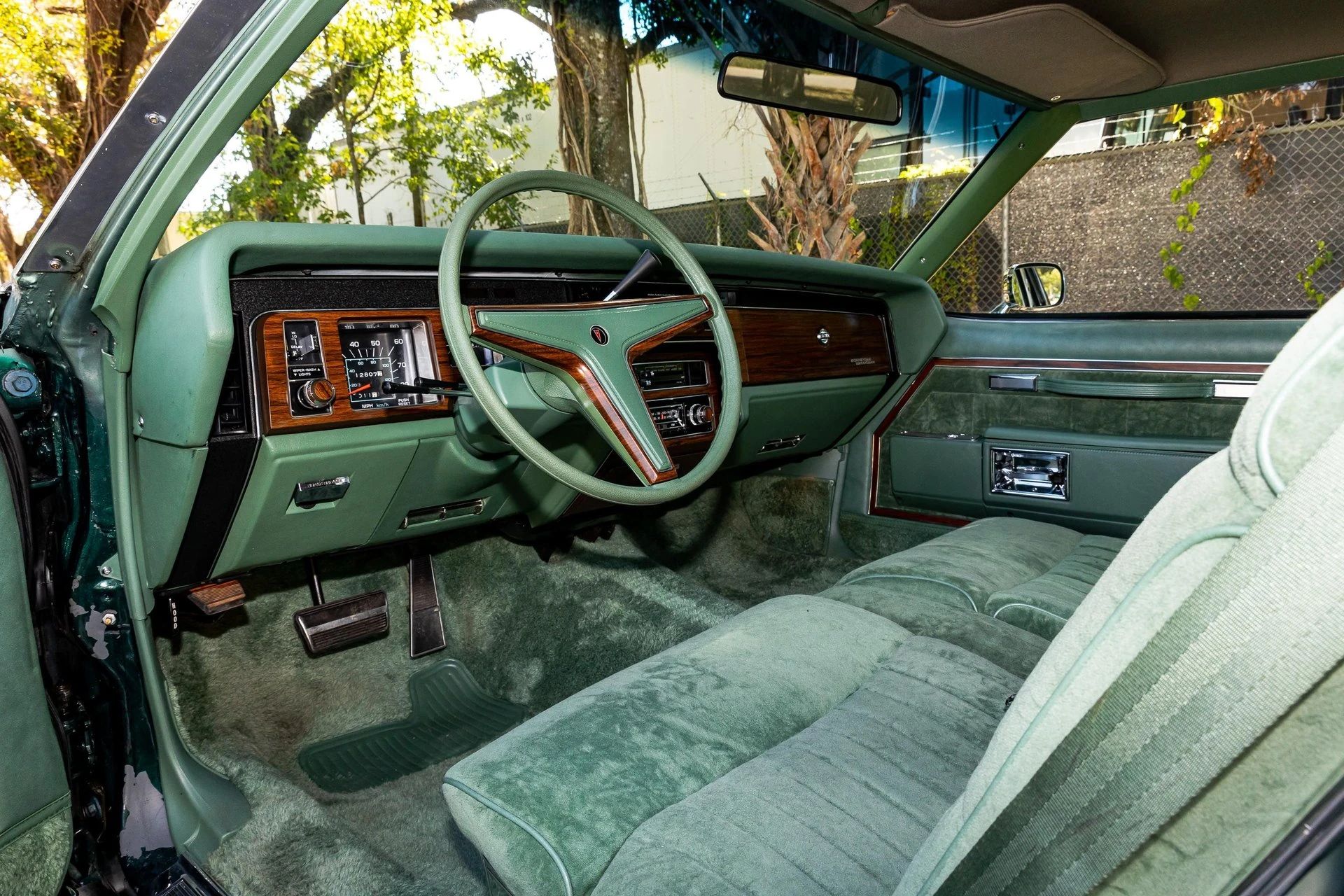 Left side of the dashboard and front seat of a 1977 Pontiac