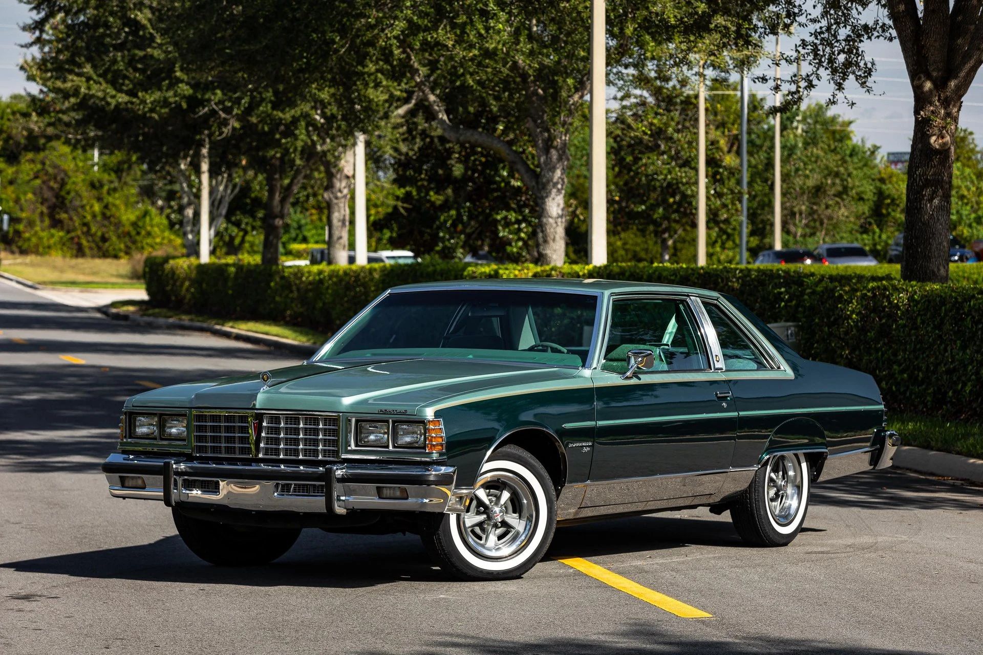 Left front 3q view of a two-tone green 1977 Pontiac Bonneville Brougham coupe