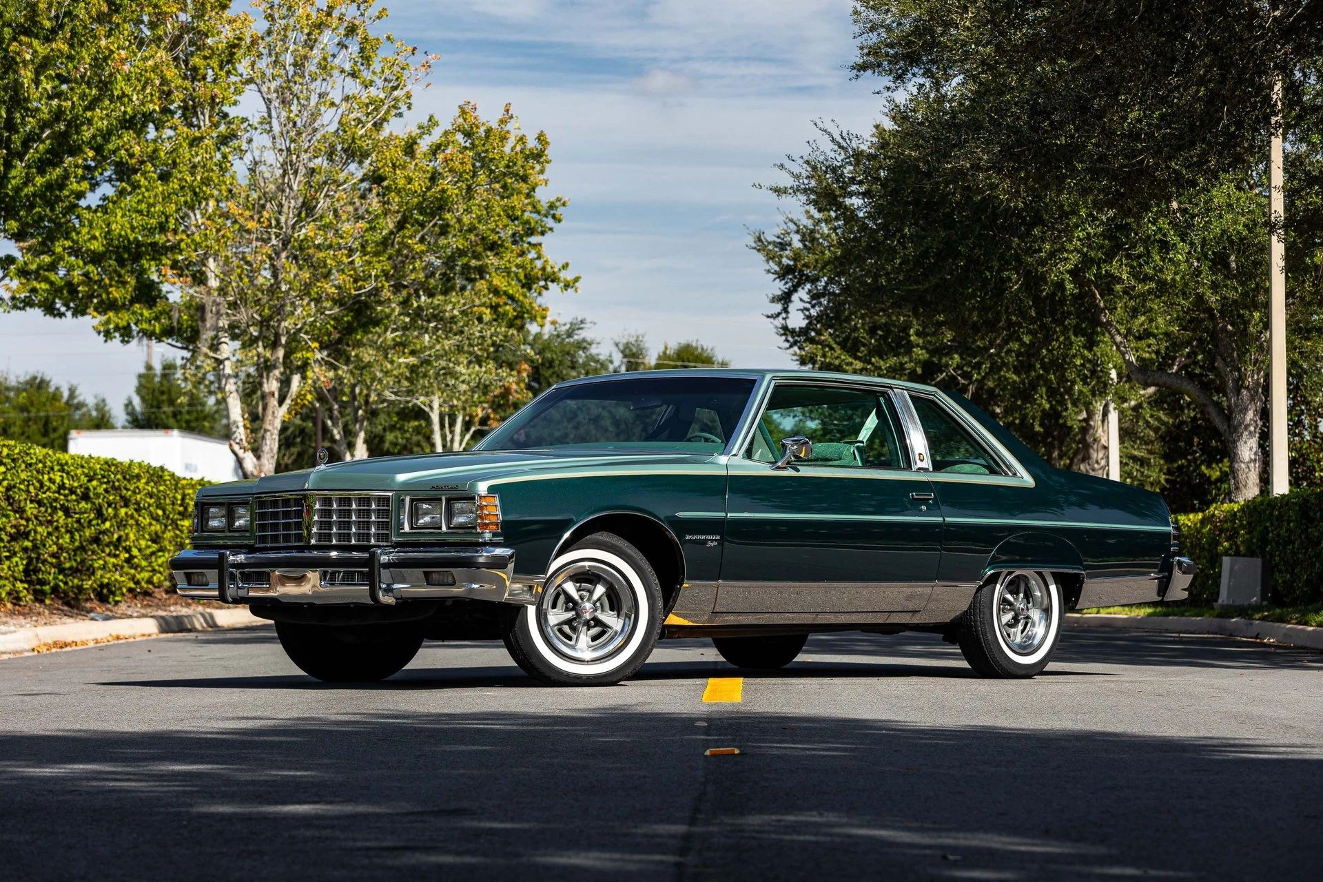 Left front 3q view of a 1977 Pontiac two-door coupe parked diagonally in the middle of a street