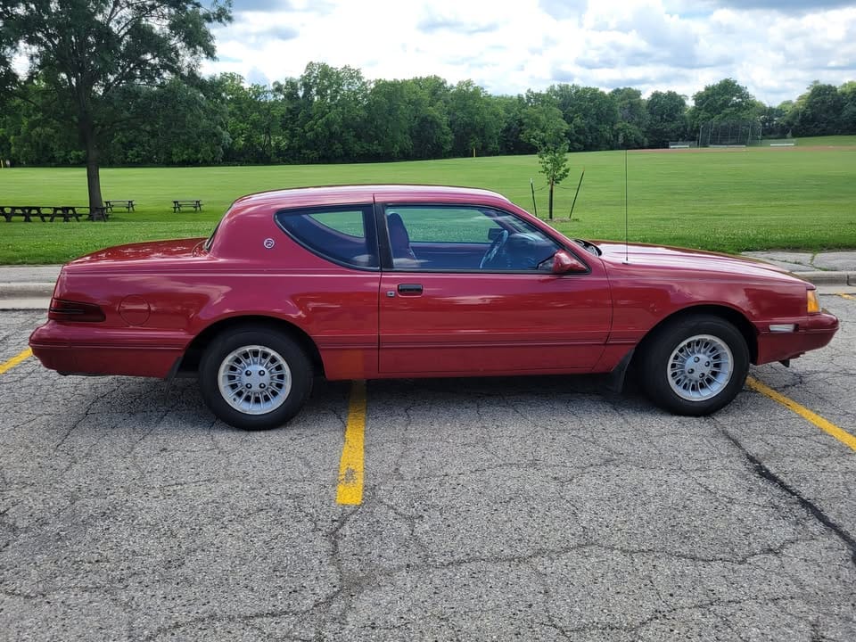 Passenger-side profile view of red 1988 Mercury Cougar XR-7