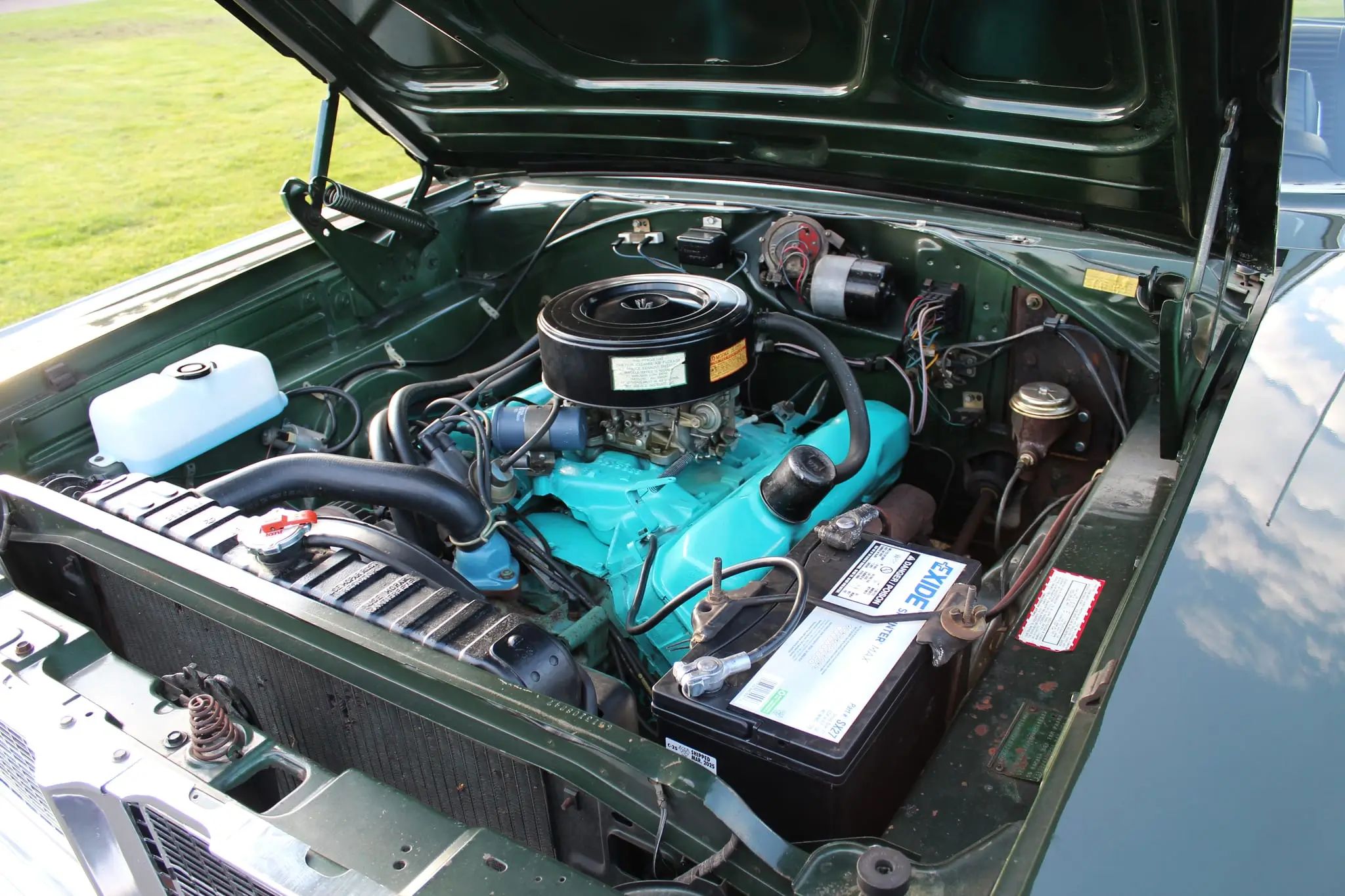 Engine compartment of dark green 1966 Dodge Coronet with 383 big-block engine