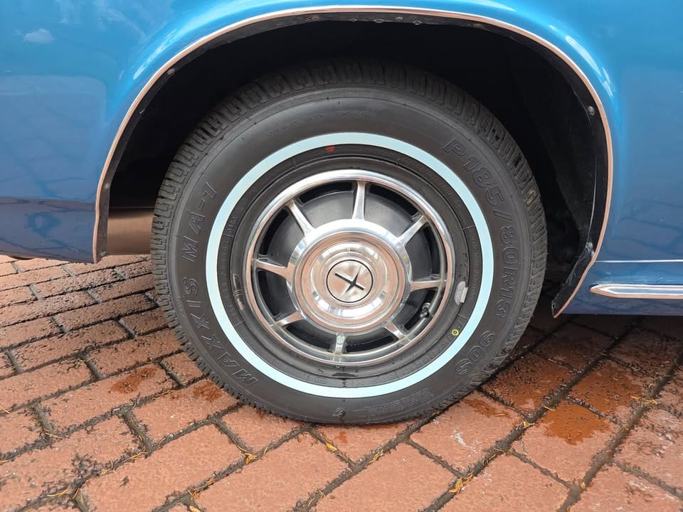 Wheel and tire of blue 1966 Chevrolet Corvair