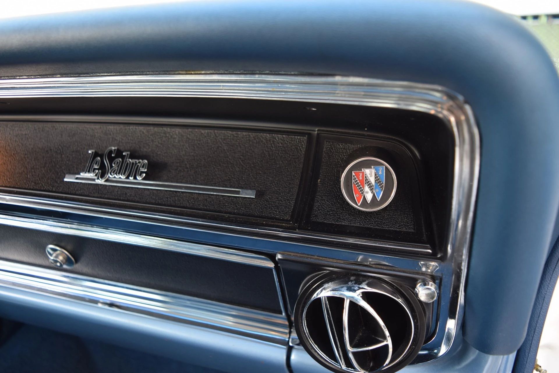 LeSabre badge and Buick shield emblems on the glove box door of a 1966 LeSabre