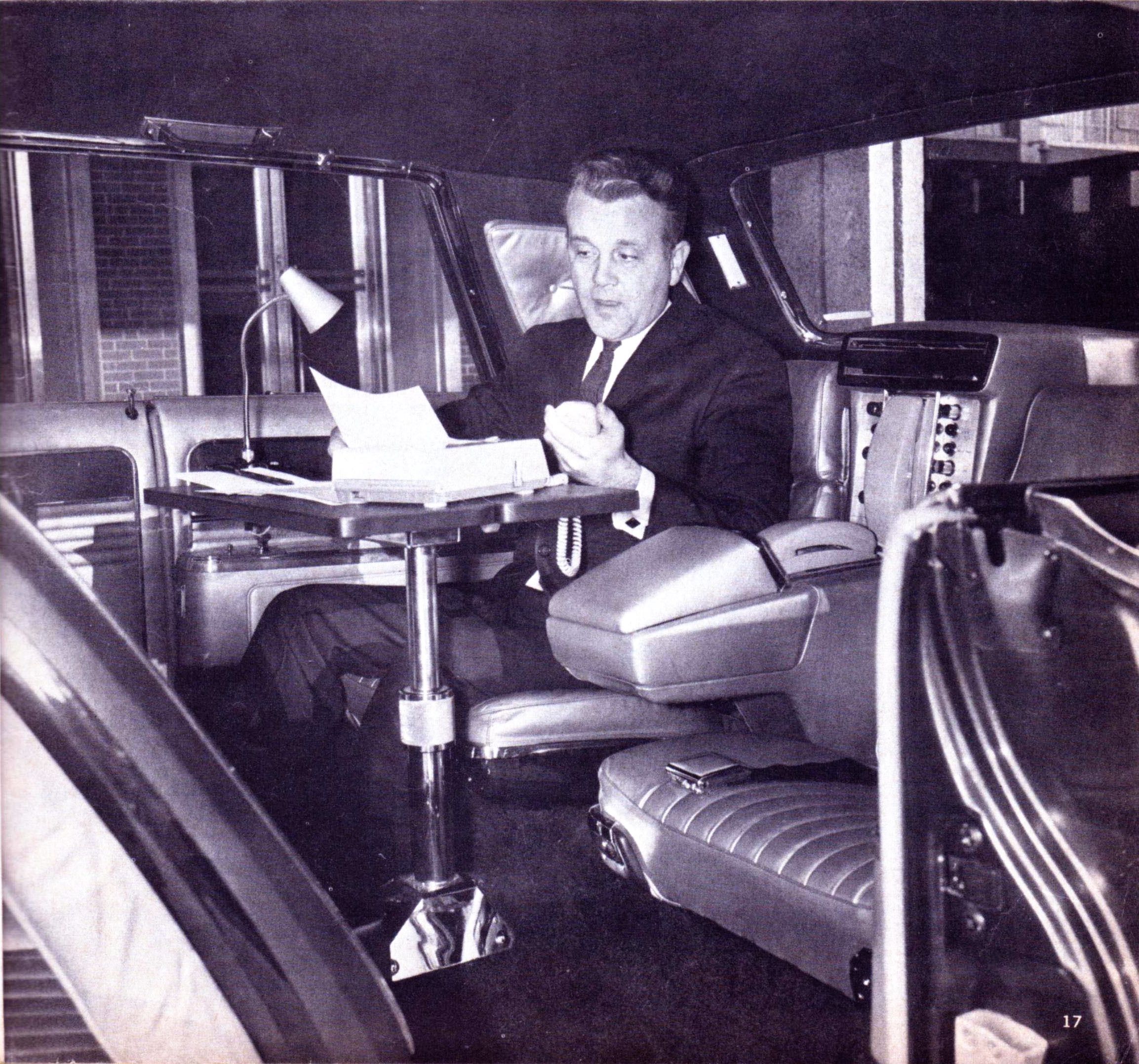 B&W photo of a man in a suit using a Dictaphone in the back of the 1966 Imperial Mobile Executive