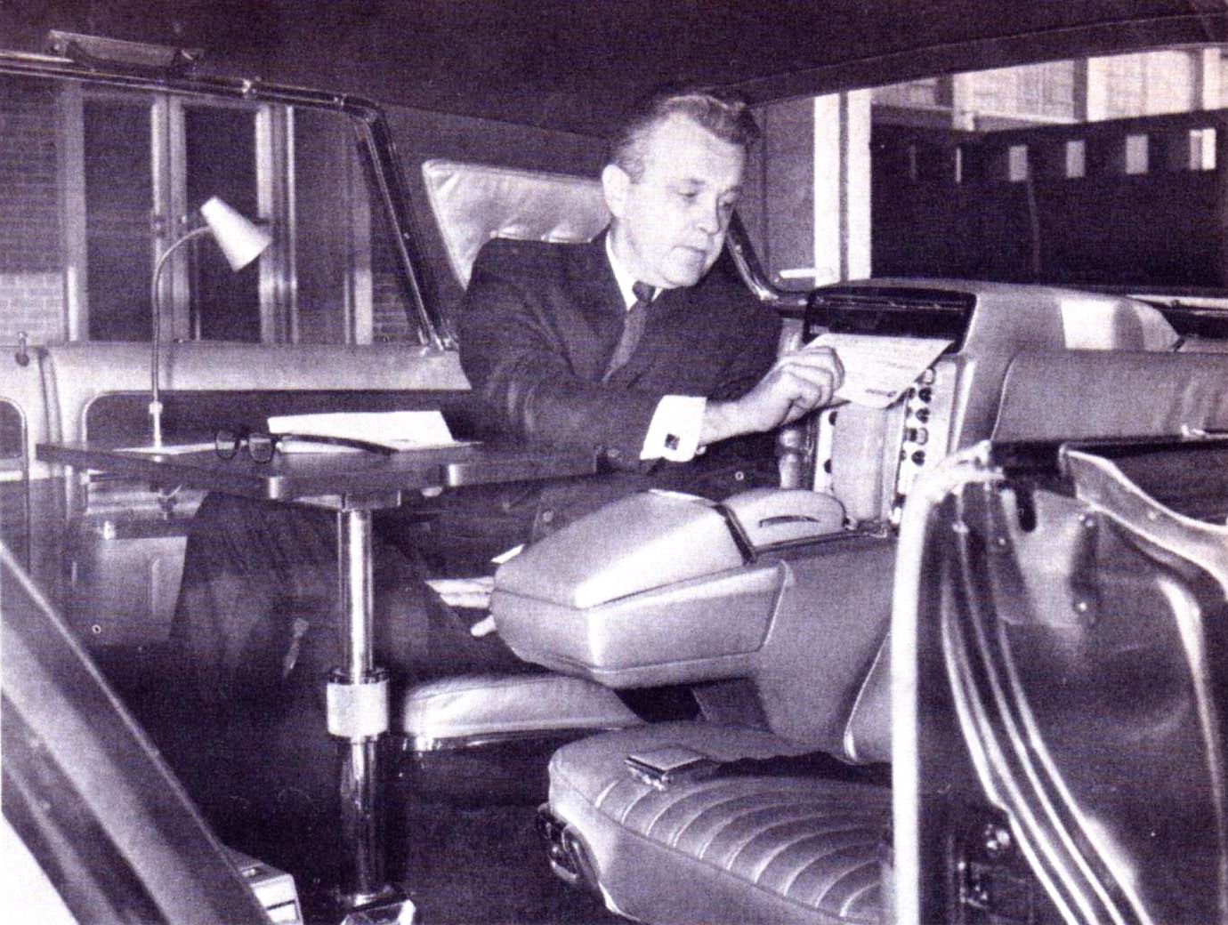 B&W photo of a man in a suit removing a page from a Datafax machine in the back of the 1966 Imperial Mobile Executive
