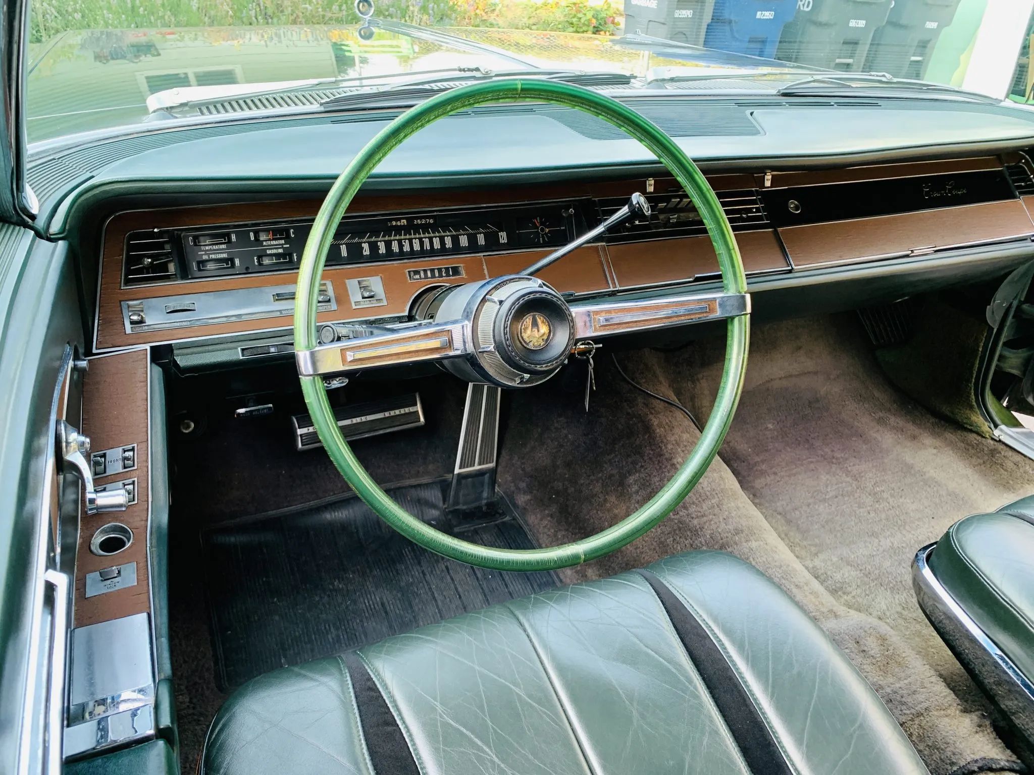 Dashboard of a 1967 Imperial, with a bright green translucent steering wheel