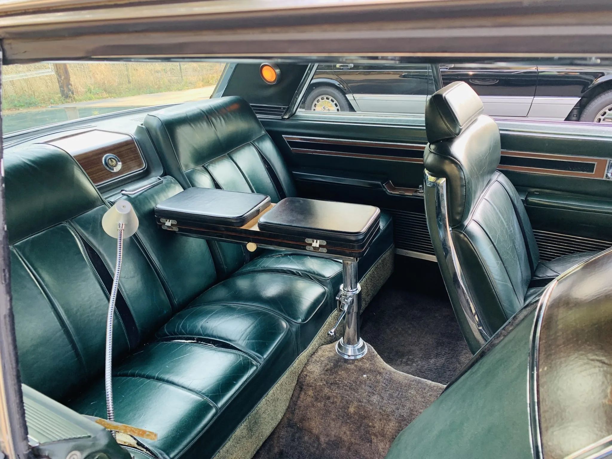 Back seat of a 1967 Imperial two-door hardtop with folding desk stowed between the rear seats