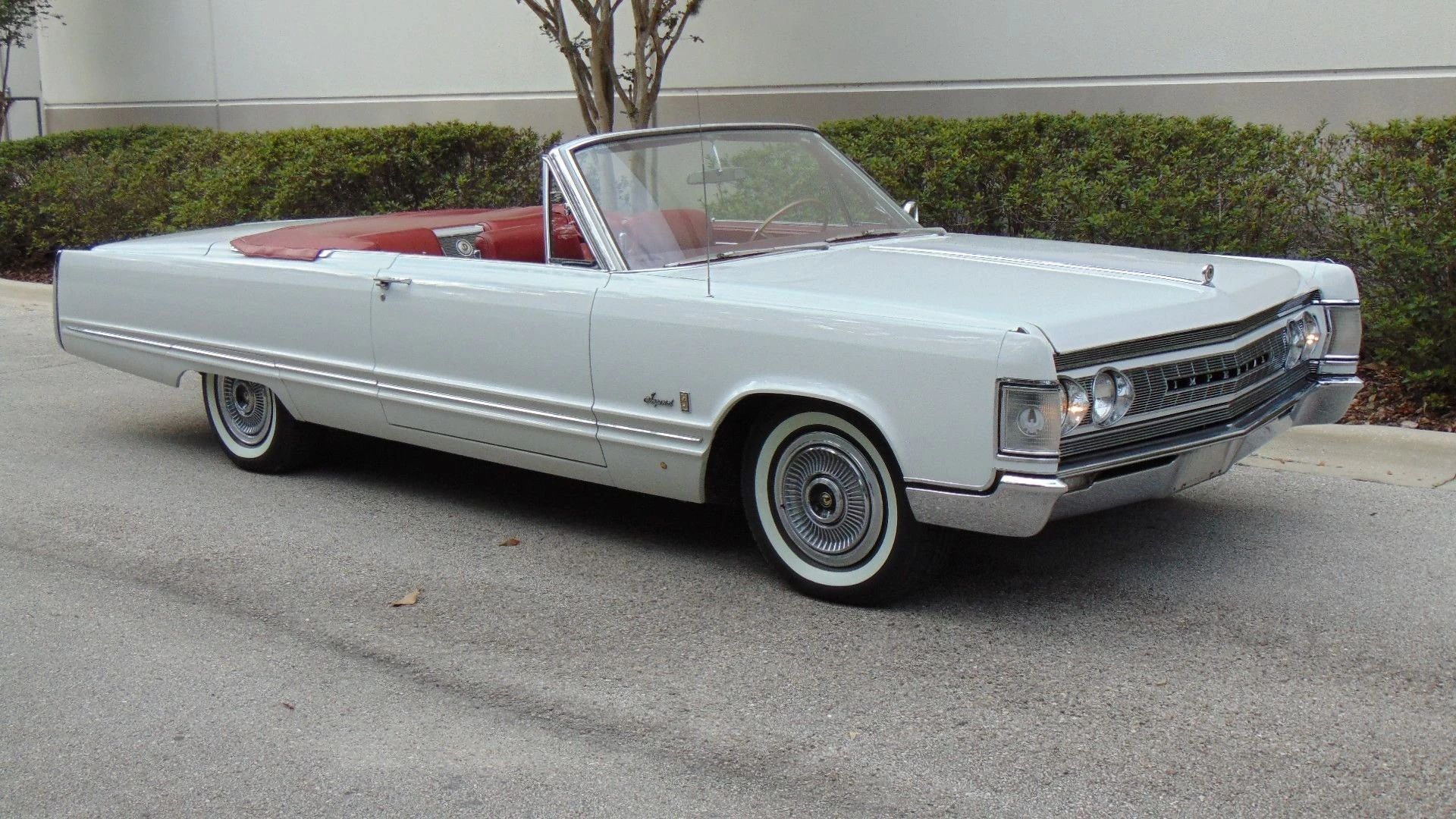 Right front 3q view of a 1967 Imperial convertible with its top down and its headlights on