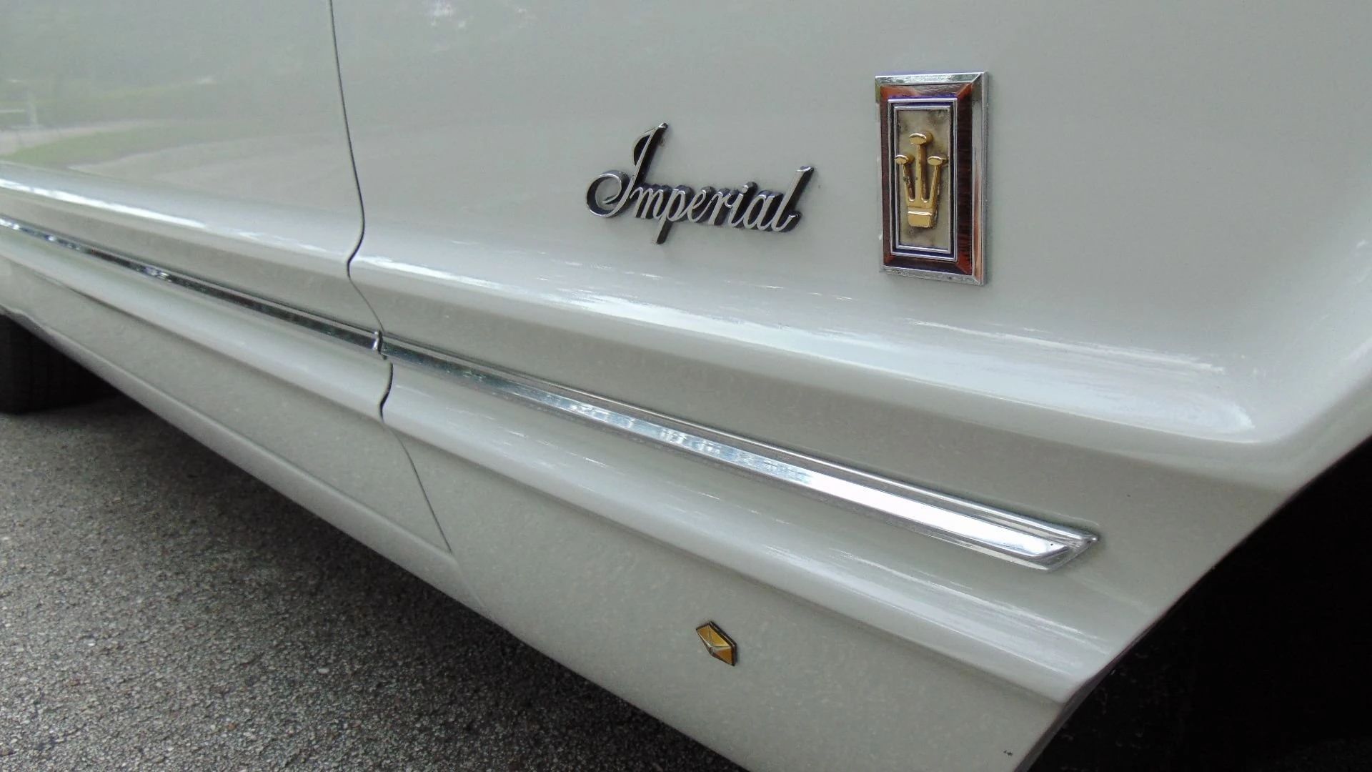 Closeup of the Imperial badges and body side creases on the right front fender of a 1967 Imperial