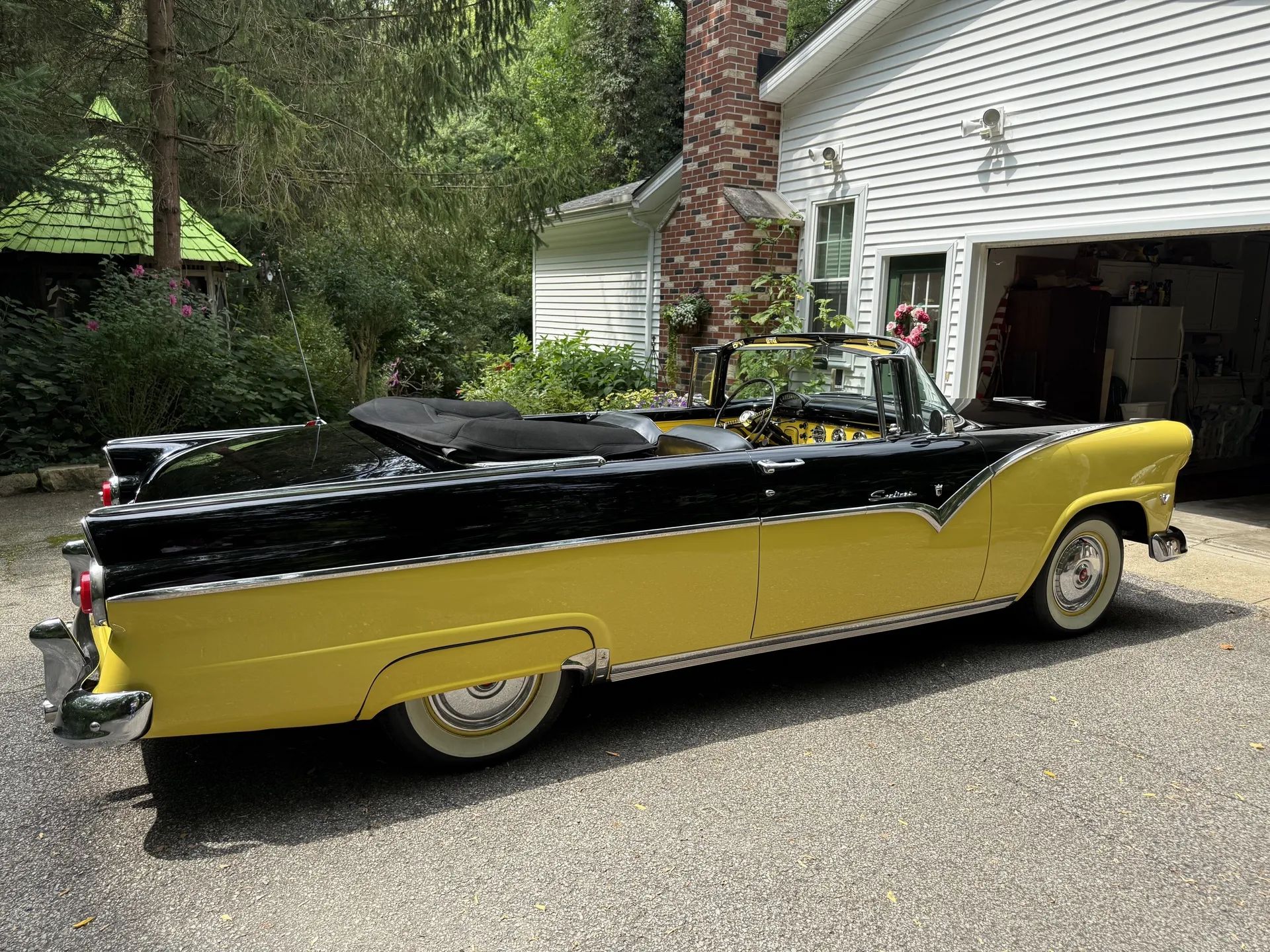 Passenger rear 3q viiew of black-and-yellow 1955 Ford Fairlane Sunliner