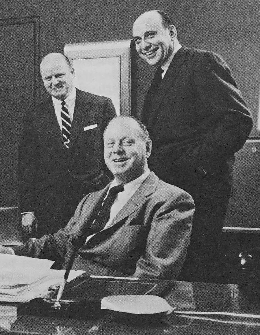 Photo of three smiling, balding white men in suits