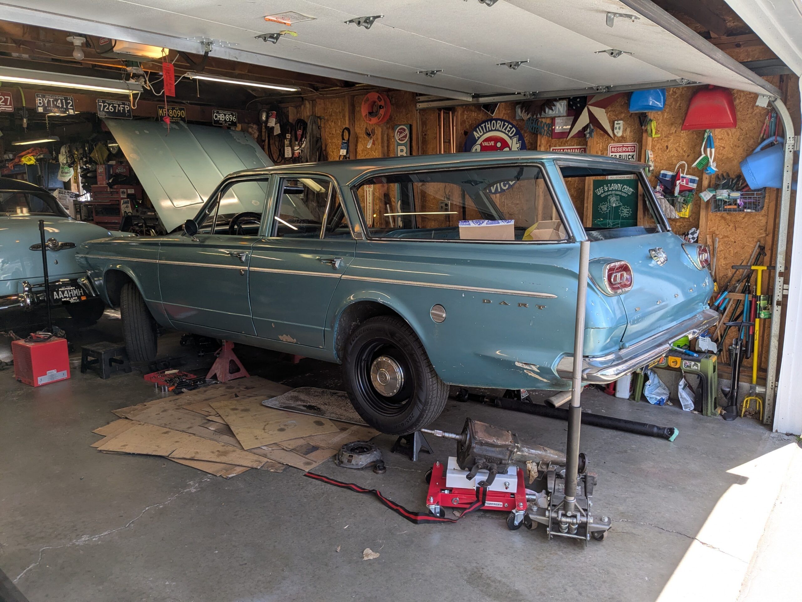 Driver rear 3q image of turquoise 1965 Dodge Dart wagon on jackstands in a garage