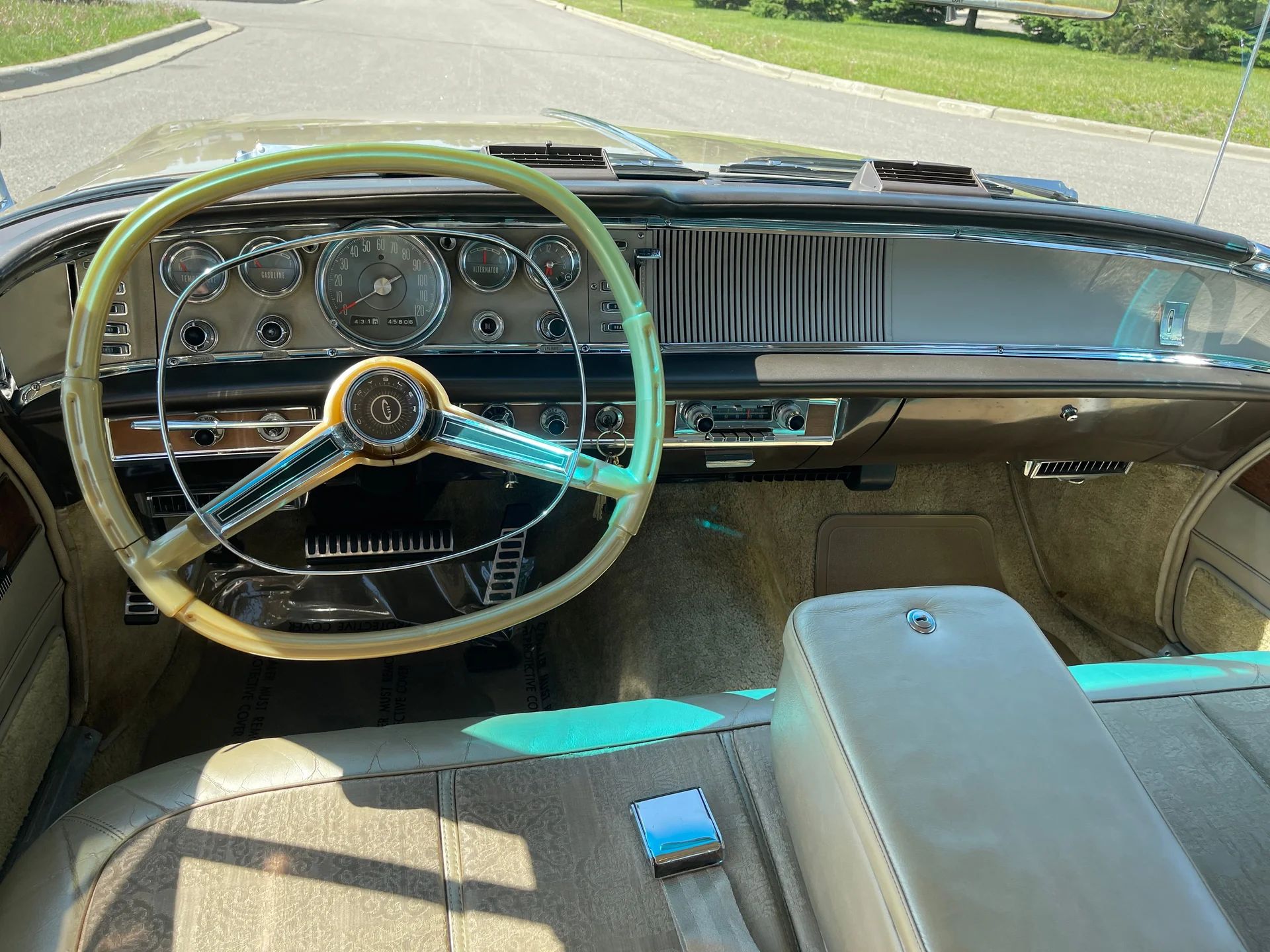 Dashboard and front seat of a 1964 Chrysler with the front armrest down