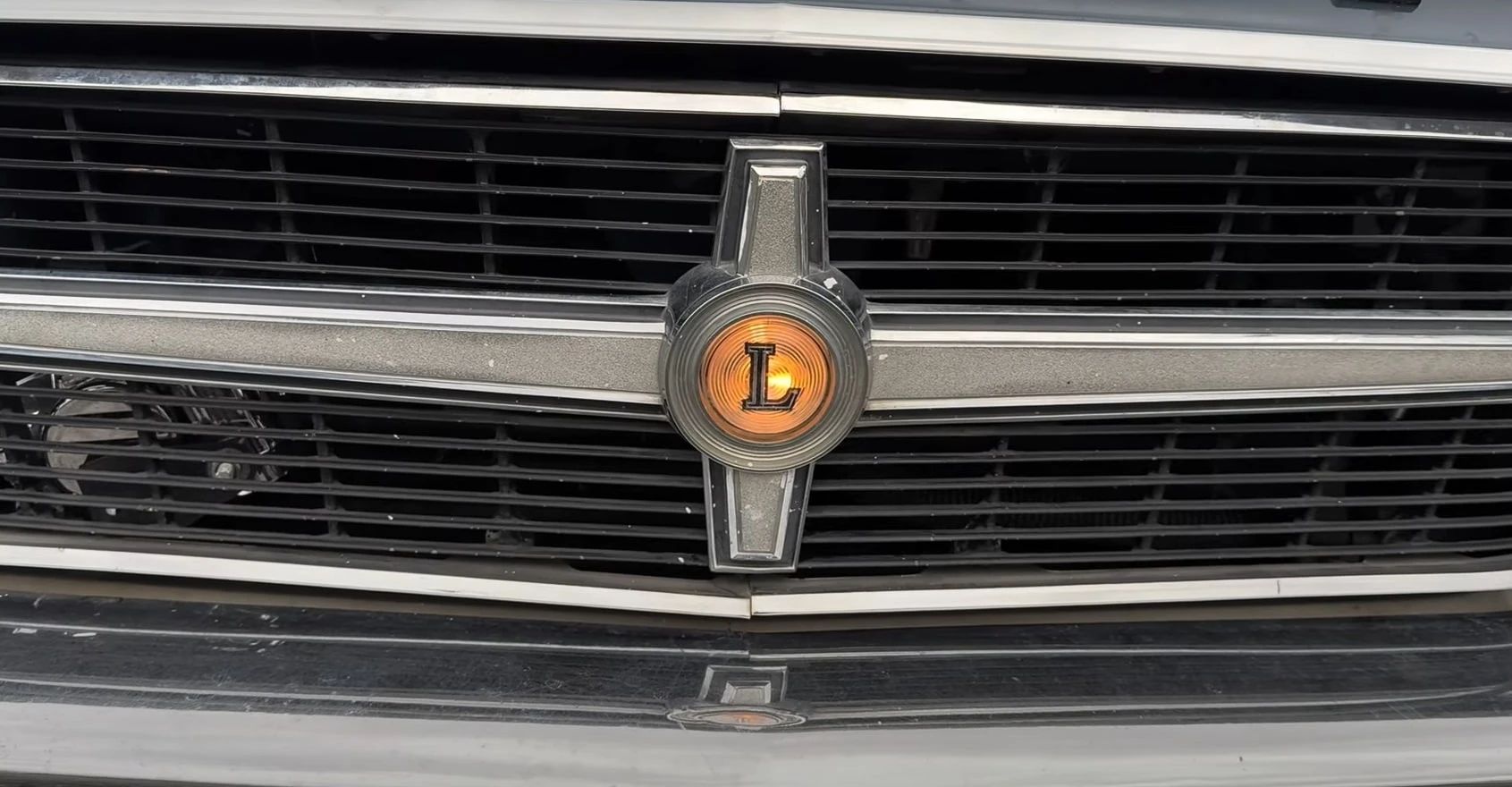 1965 Chrysler 300-L Convertible: Ultra-Rare 4-Speed Manual Transmission In The Last And Least Of The Letter Cars 22 Closeup of the "L" badge on the grille of a 1965 Chrysler 300-L, illuminated and glowing amber