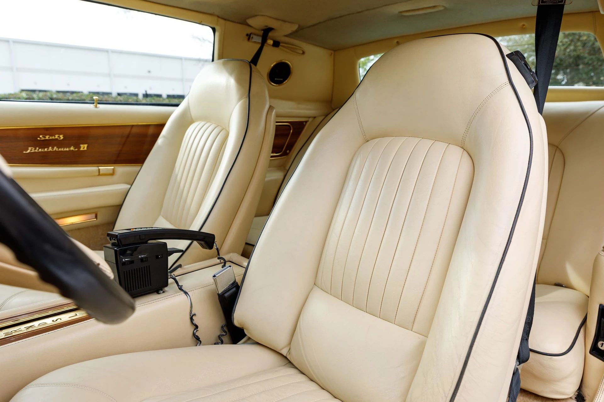 Front bucket seats upholstered in tan leather with black piping