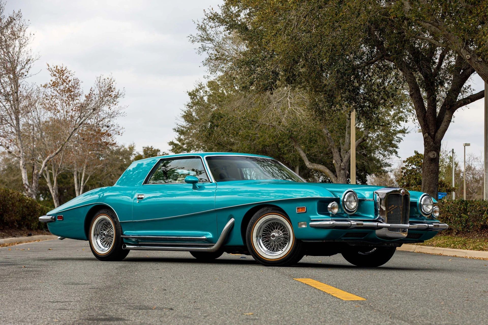 Right front 3q view of a turquoise 1978 Stutz coupe parked diagonally in the middle of a street