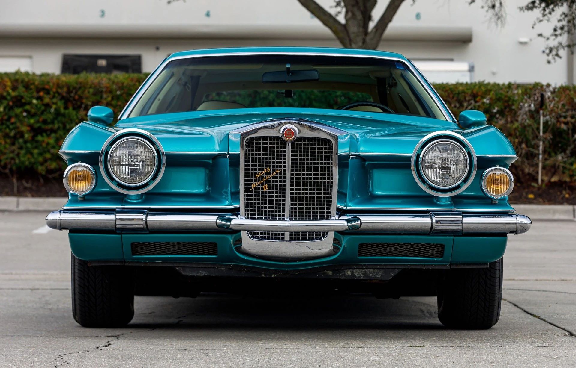 Head-on view of a goggle-eyed turquoise Stutz Blackhawk