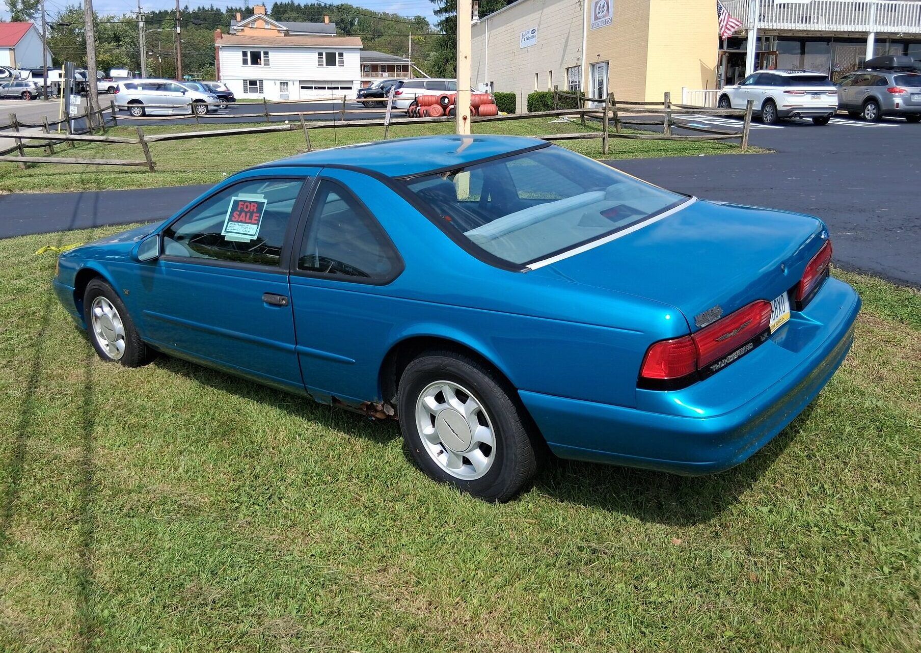 1994 Ford Thunderbird LX: As Teal As You Remember It, But A Little Rustier 7 Driver rear 3q picture of teal 1994 Ford Thunderbird parked on grass in front of a parking lot