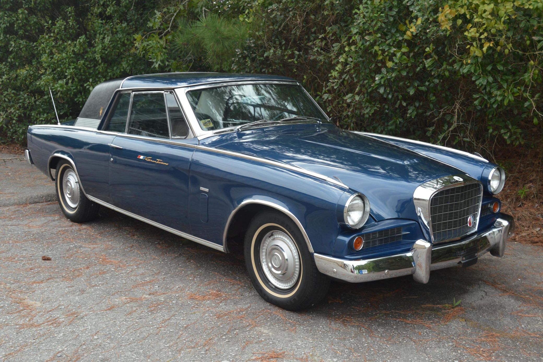 Passenger front 3q picture of dark blue 1963 Studebaker GT Hawk with wooded background