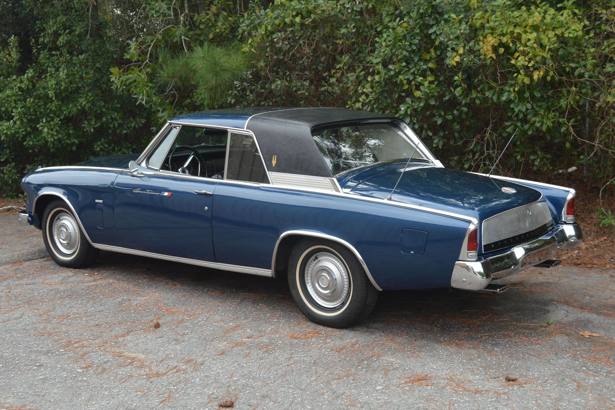 Driver rear 3q image of dark blue 1963 Studebaker GT Hawk with black half vinyl roof