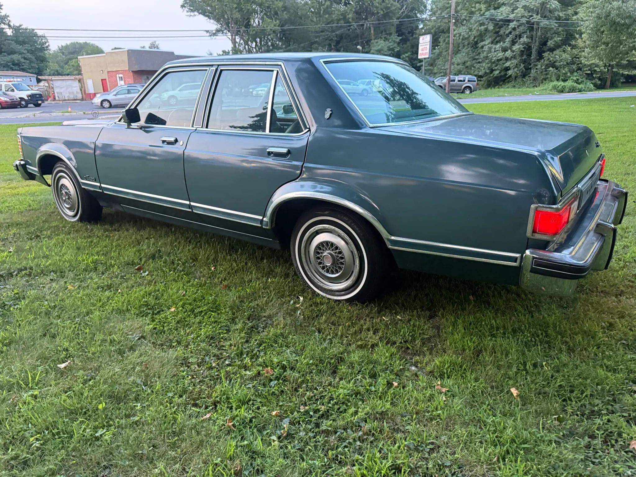 Driver rear 3q image of blue 1976 Mercury Monarch Ghia Sedan