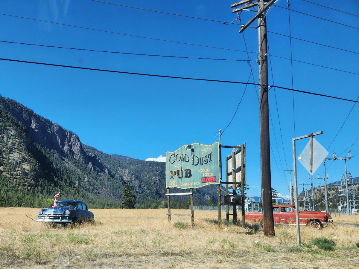 Old cars next to a sign.