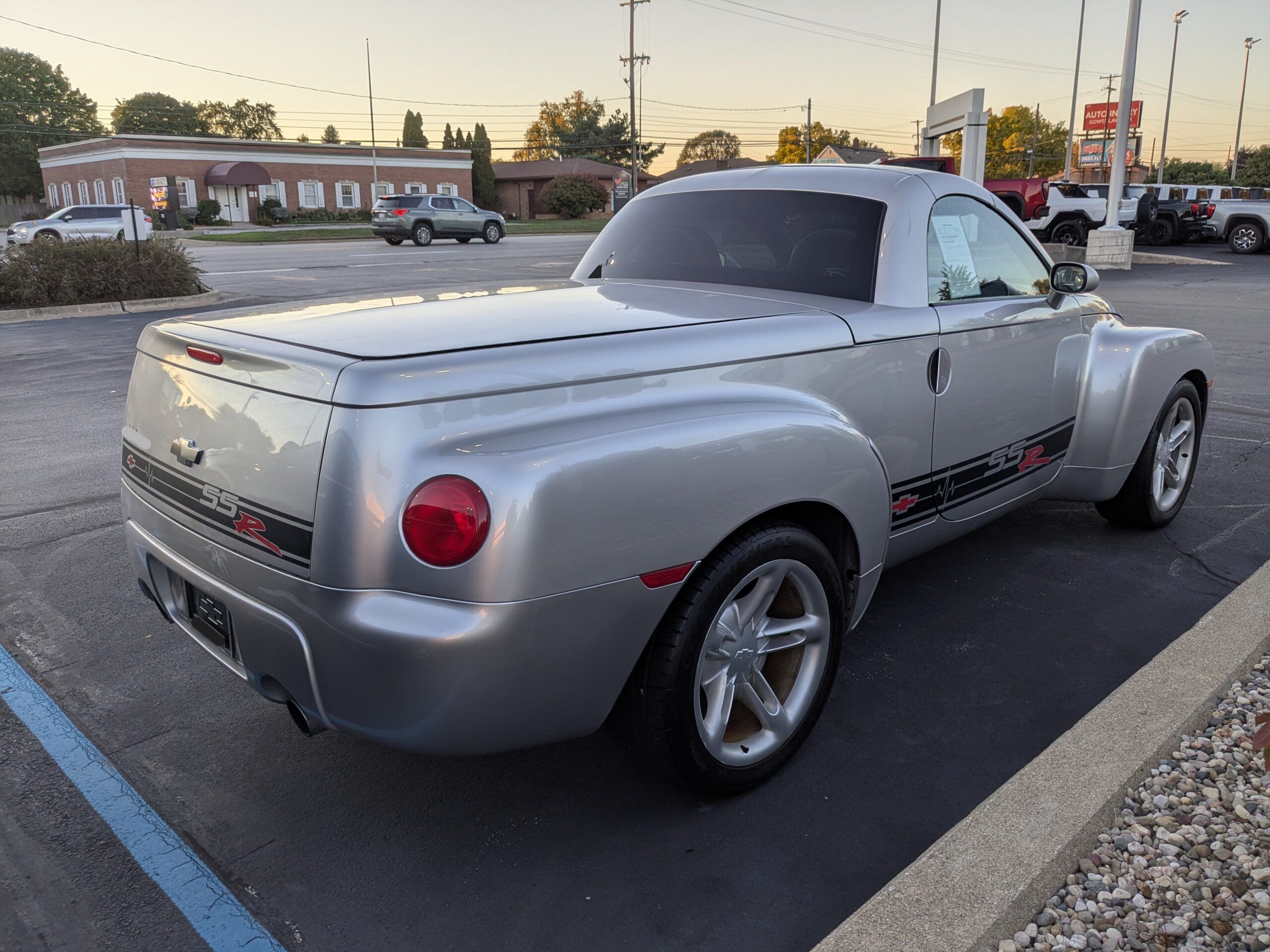 2004 Chevrolet SSR: A Convertible Two-Seater Truck? A Retro Curiosity Worth A Second Look 8 Passenger rear 3q picture pf silver 2004 Chevrolet SSR in dealer parking lot at dusk