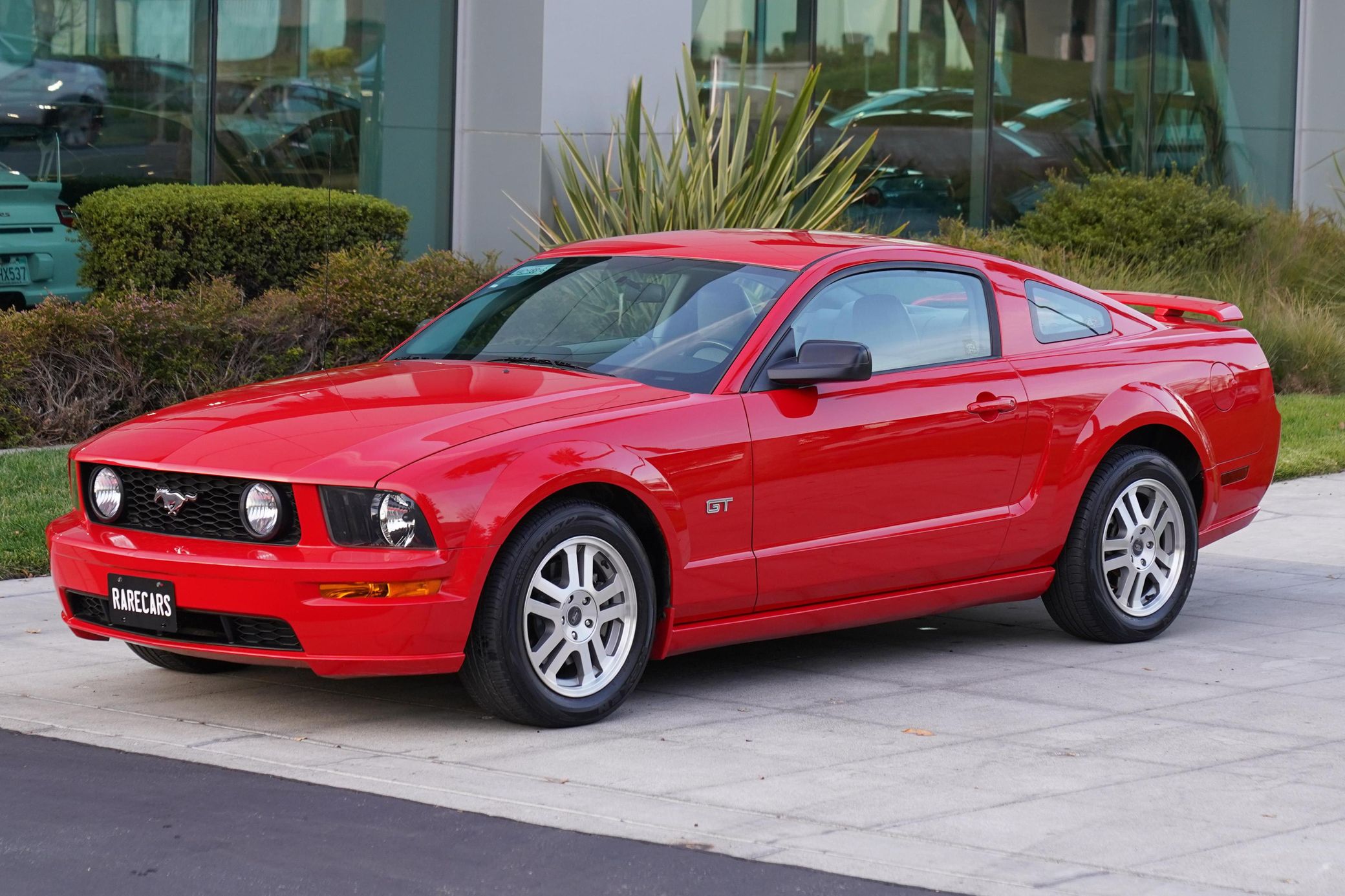 2004 Chevrolet SSR: A Convertible Two-Seater Truck? A Retro Curiosity Worth A Second Look 4 Driver front 3q picture of red 2005 Ford Mustang GT at a car dealership