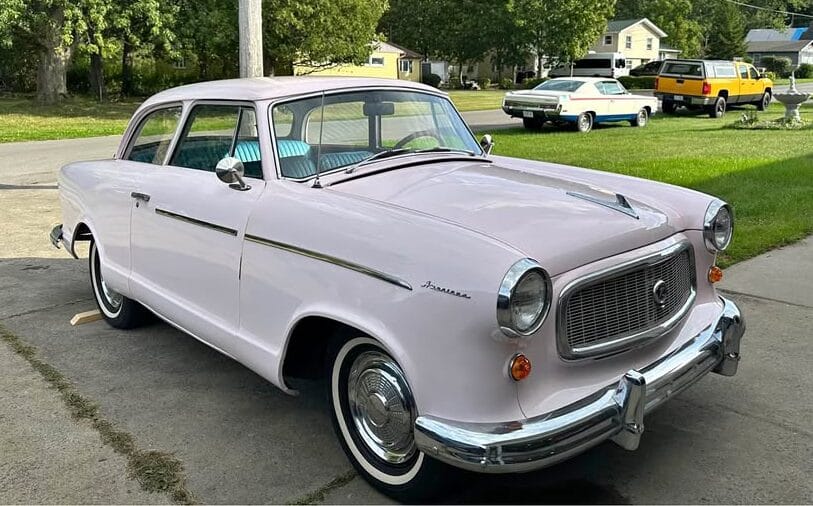 1960 Rambler American Super: A Cute And Fairly Inexpensive Way To Draw Attention 5 Passenger front 3q picture of pink 1960 Rambler American in a driveway with an AMC Rebel Machine in the background