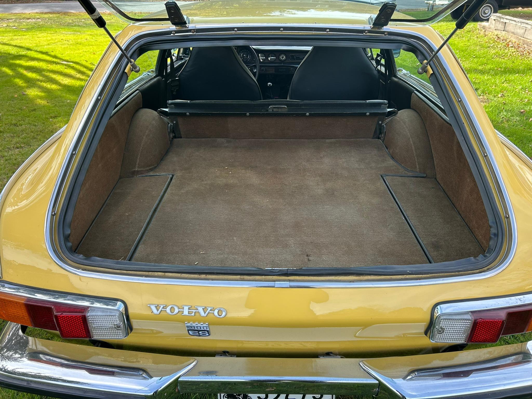 Rear hatch and luggage compartment of yellow 1972 Volvo 1800ES