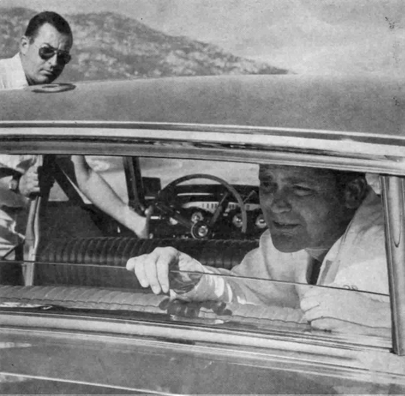 1963 Mercury Monterey S-55 Two-Door Hardtop: One-Year-Only Bucket-Seat Breezeway 15 B&W photo of a man poking at the open rear window of a 1963 Mercury Breezeway sedan