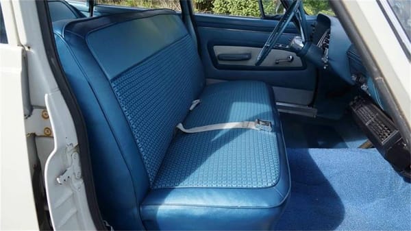Vintage R&T Review: 1960 Valiant — A Technical Analysis Of Chrysler's New Compact 5 Front seat of a white 1960 Valiant V200 with blue interior, viewed through the open front passenger door
