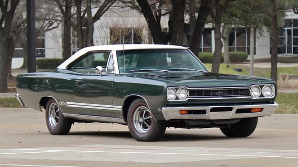 Right front 3q view of a Forest Green 1968 Plymouth GTX hardtop with a white vinyl top and styled road wheels