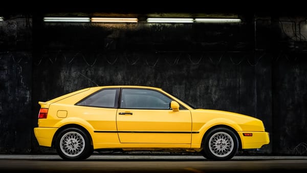 Right side view of a yellow 1990 Volkswagen Corrado photographed in a dark studio