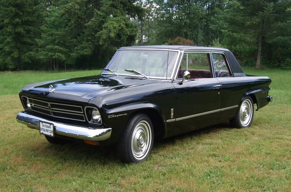 Left front 3q view of a black 1966 Studebaker Daytona two-door sedan parked on the grass