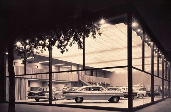 Exterior photo of a dealer showroom with an array of 1959 Chevrolet cars