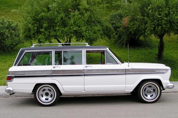 1966–1971 Jeep Super Wagoneer and Wagoneer Custom Special: These Luxury SUVs Were Way Ahead Of Their Time, So Why Didn't They Sell? 17 Right side view of a Glacier White 1966 Jeep Super Wagoneer with non-stock wheels