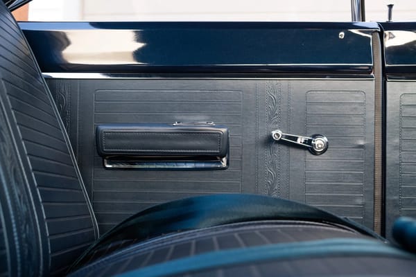 Closeup of the rear seat and left rear quarter panel of a 1967 Plymouth GTX hardtop with blue vinyl upholstery