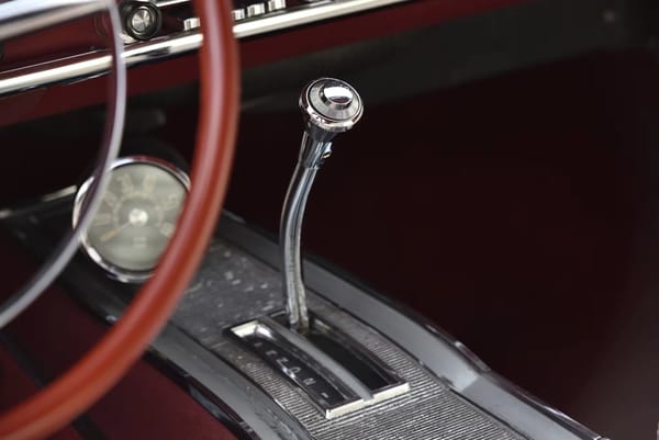 Console-mounted TorqueFlite shifter on a 1967 Plymouth GTX with red dashboard and carpeting