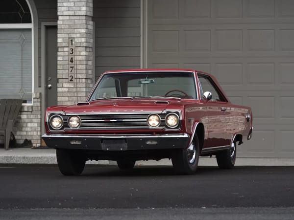 Front view of a Bright Red 1967 Plymouth GTX hardtop with its headlights on