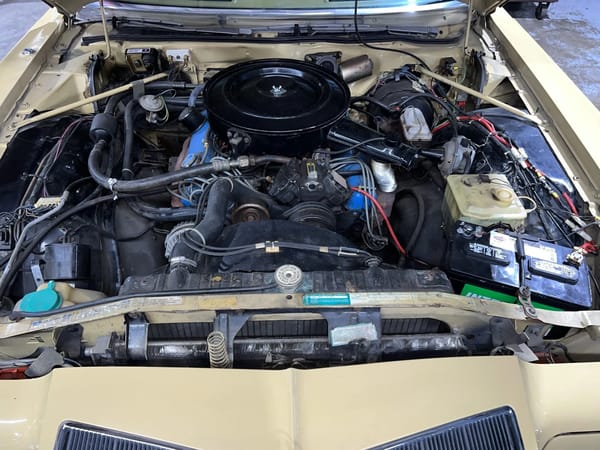 Chrysler 440 engine under the hood of a gold 1974 Imperial LeBaron