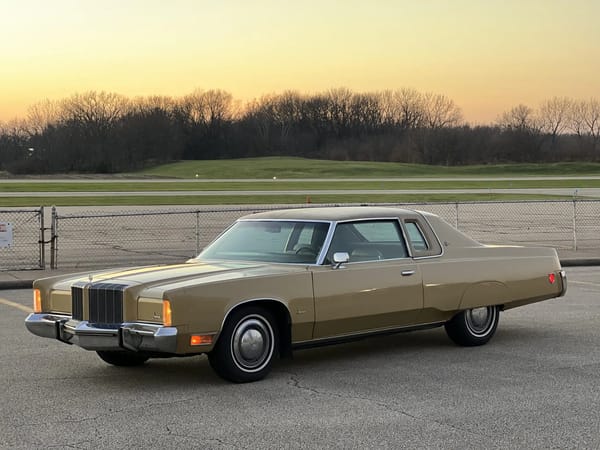 Left front 3q view of a gold 1974 Imperial LeBaron two-door hardtop with Crown Coupe package, photographed at sunset with the parking lights on