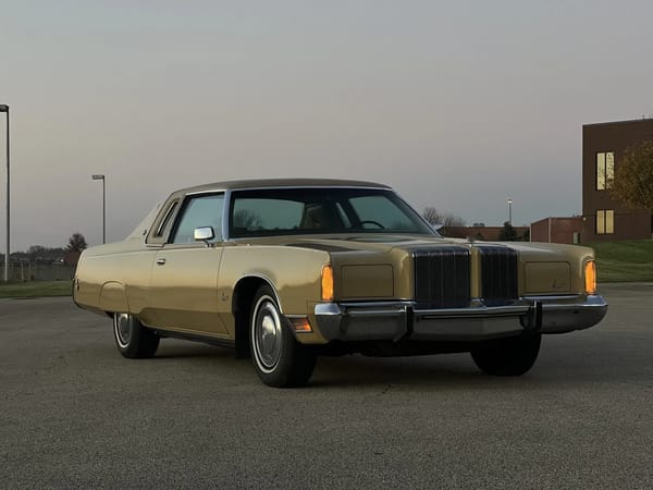Right front 3q view of a gold 1974 Imperial LeBaron Crown Coupe, photographed at sunset with the parking lights on