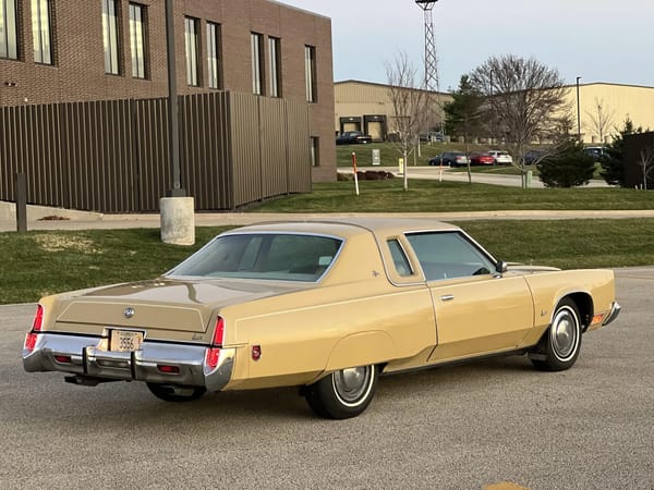 Right rear 3q view of a gold 1974 Imperial LeBaron Crown Coupe, photographed at sunset with its parking lights on