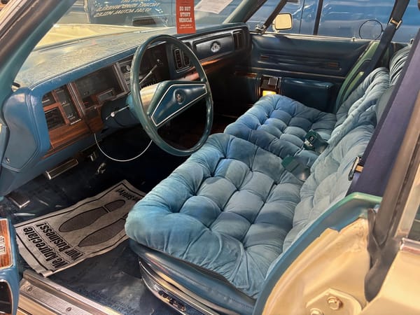 Front seat of a 1976 Chrysler New Yorker Brougham with blue velour upholstery
