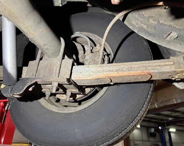 Rear leaf spring and disc brake on a 1974 Imperial LeBaron, seen from underneath