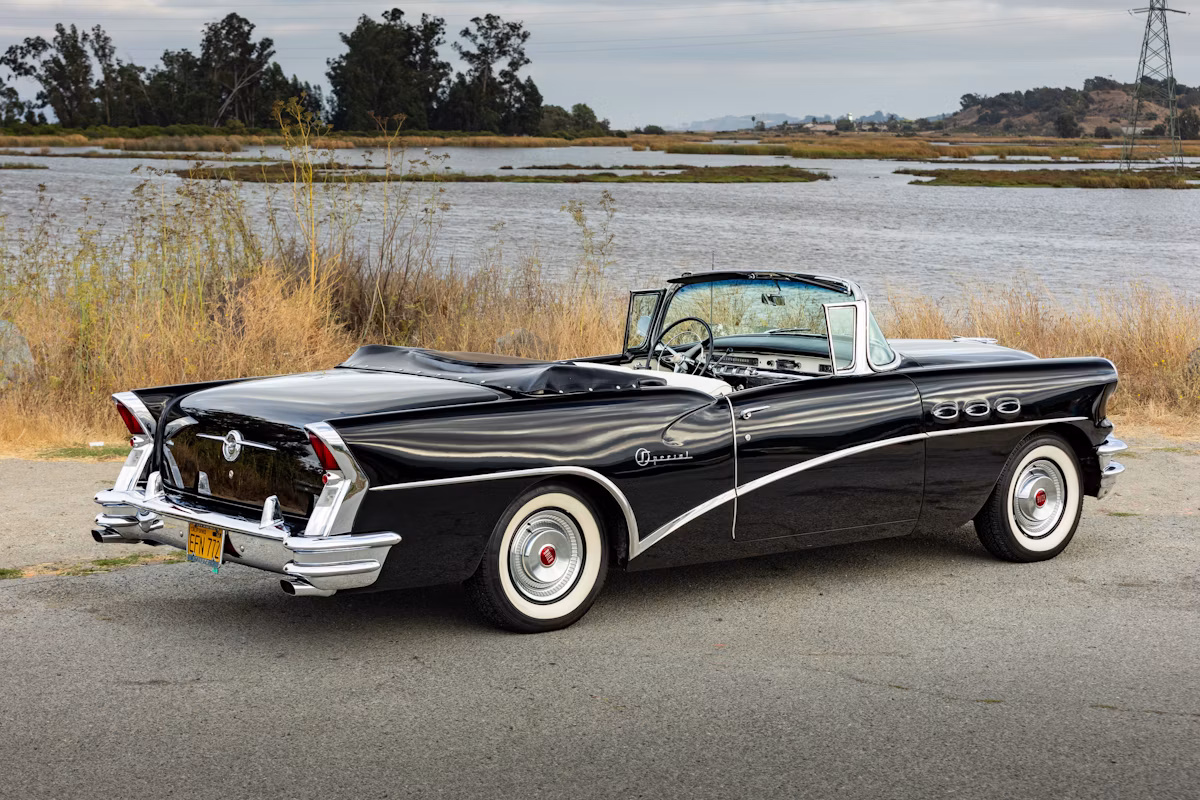 1956 Buick Special Convertible: A Two-Owner Fifties Dreamboat 7 Passenger rear 3q picture of black 1956 Buick Special Convertible in front of a lake
